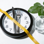 Zegar w formie talerza i miarka krawiecka obrazujące post przerywany ile schudne